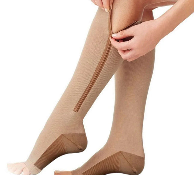 Beige zippered compression socks for legs with open toe design, being worn by a person